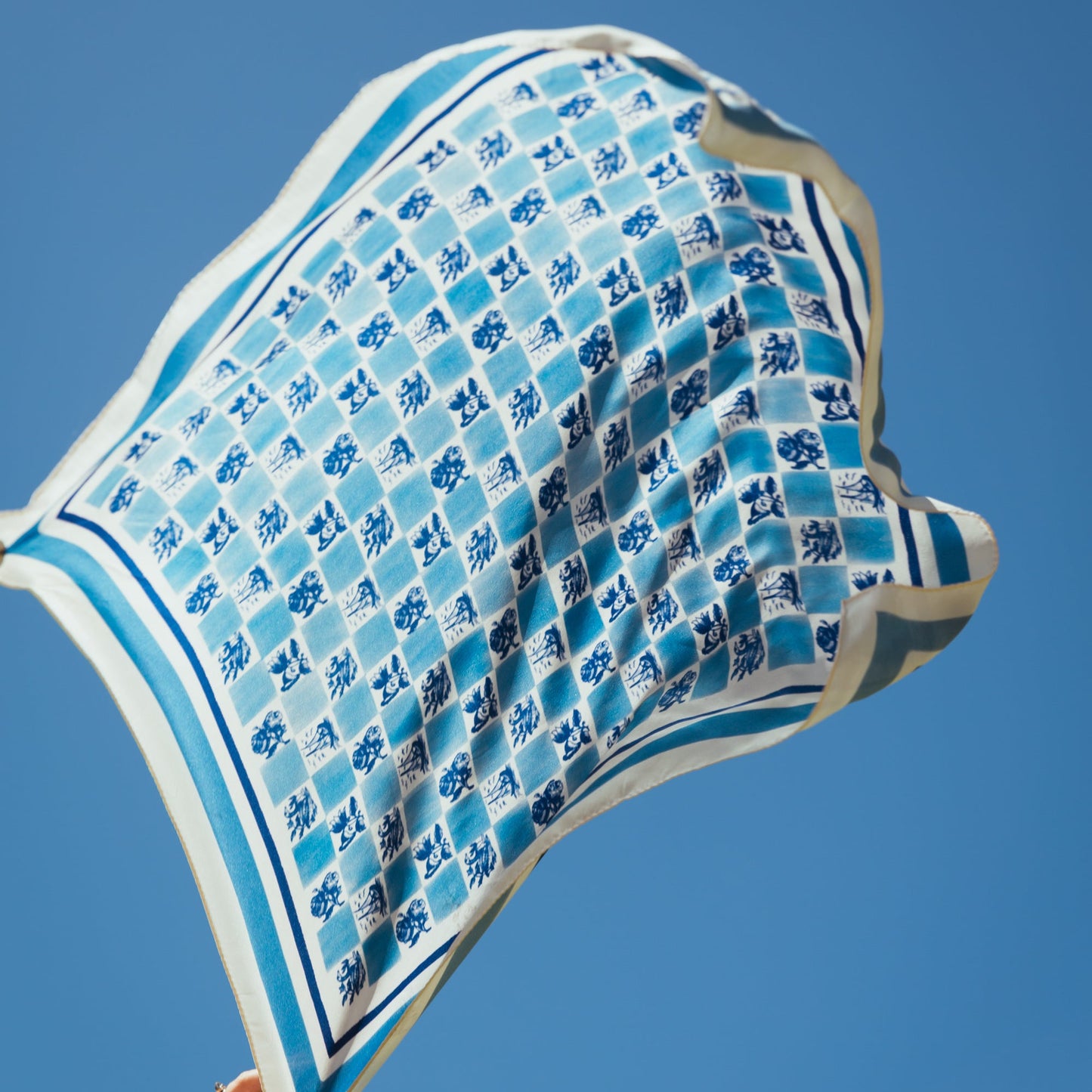 Blue silk foulard Santa Luzia is being throuwn in the air, flowing. 